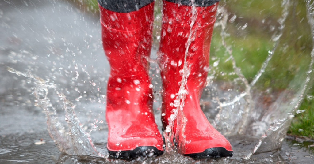 Red rain boots splashing in a puddle indicate the need for a "rainmaker," AKA business development manager.