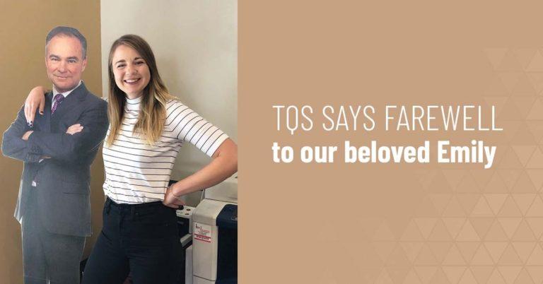 Emily, a lovely young woman wearing a white and black striped shirt and black pants, rests her arm around a cardboard cutout of a man in a suit. The accompanying text reads: "TQS SAYS FAREWELL to our beloved Emily."