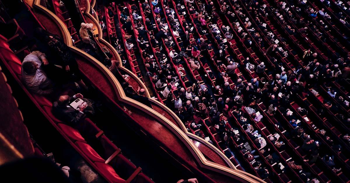 An overhead view of businesspeople sitting in a theatre.