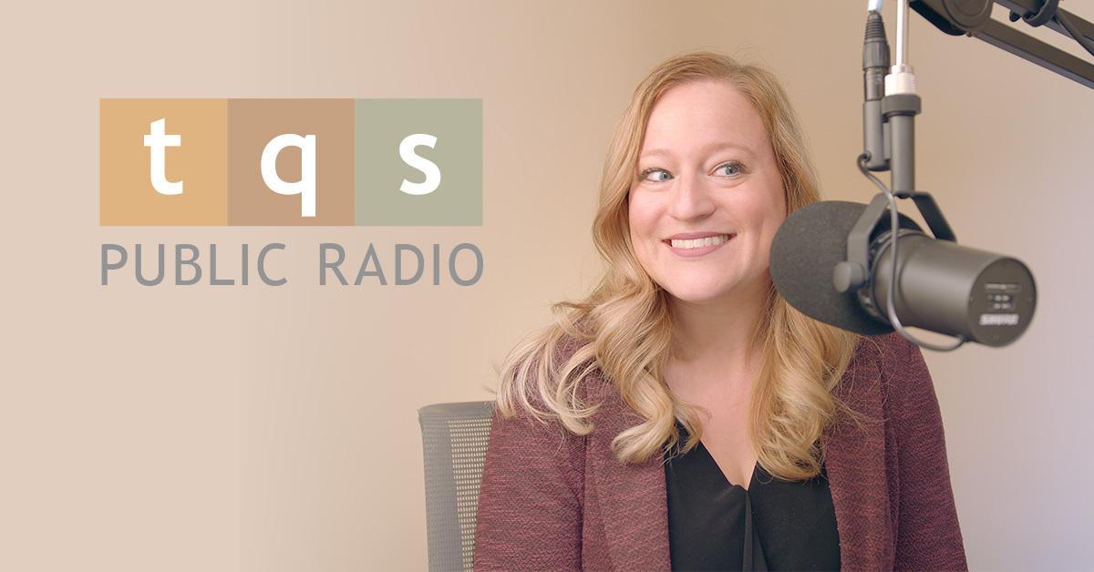 TQS Public Radio presents: Alyssa Boczar, a blond-haired woman wearing a dark red-colored cardigan, sits in front of a radio station-style microphone. White letters over an orange, brown, and olive background form "tqs" in the style of the NPR radio logo. "PUBLIC RADIO" is printed in gray beneath the logo.